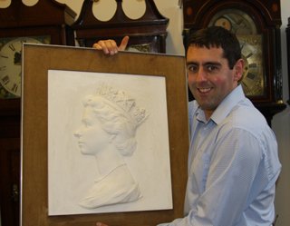 Auctioneer Ben Gamble with the Machin cast, which sold for &pound;18,000